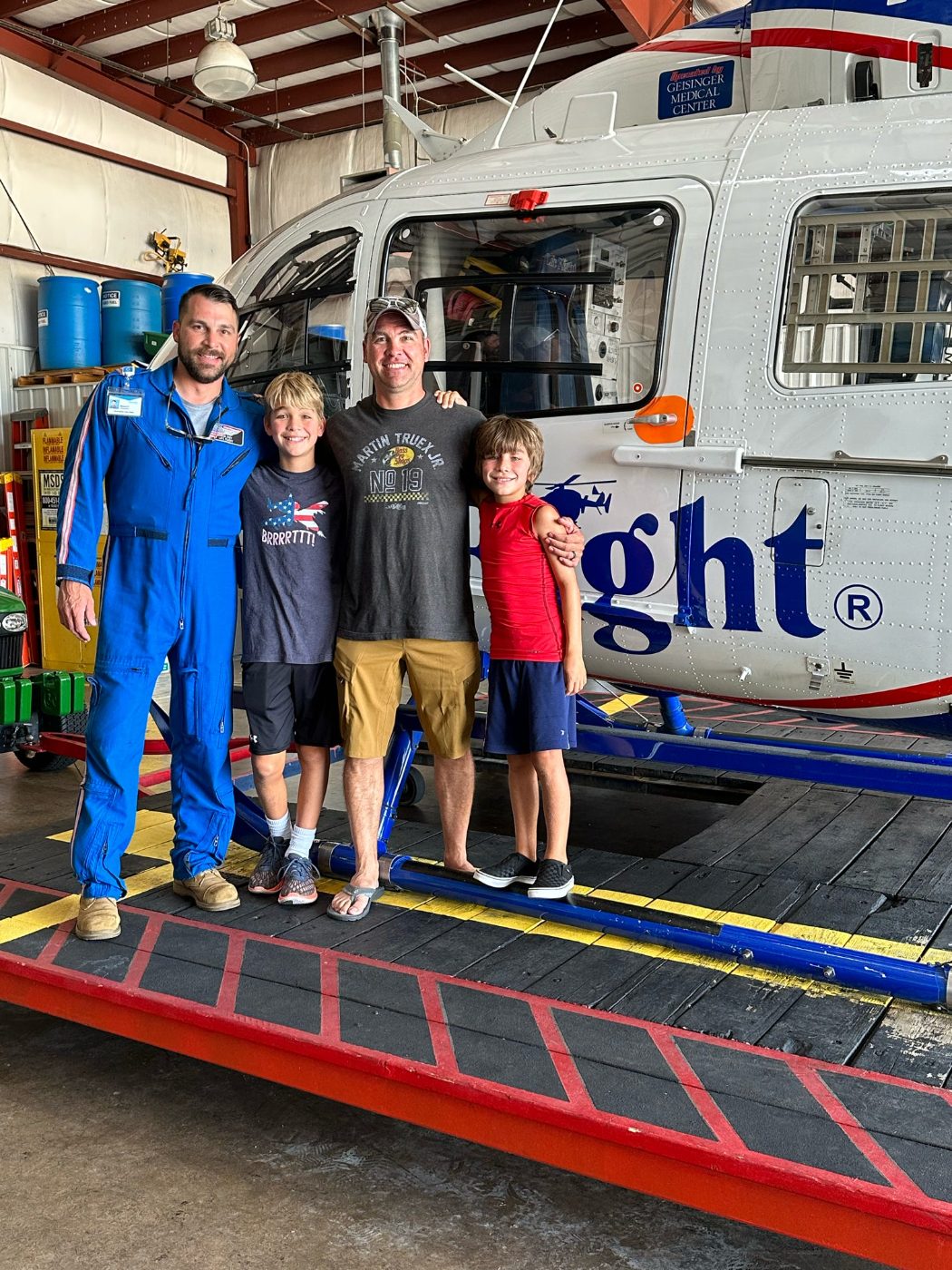 Rob in a Life Flight flight suit with kids in front of the helicopter